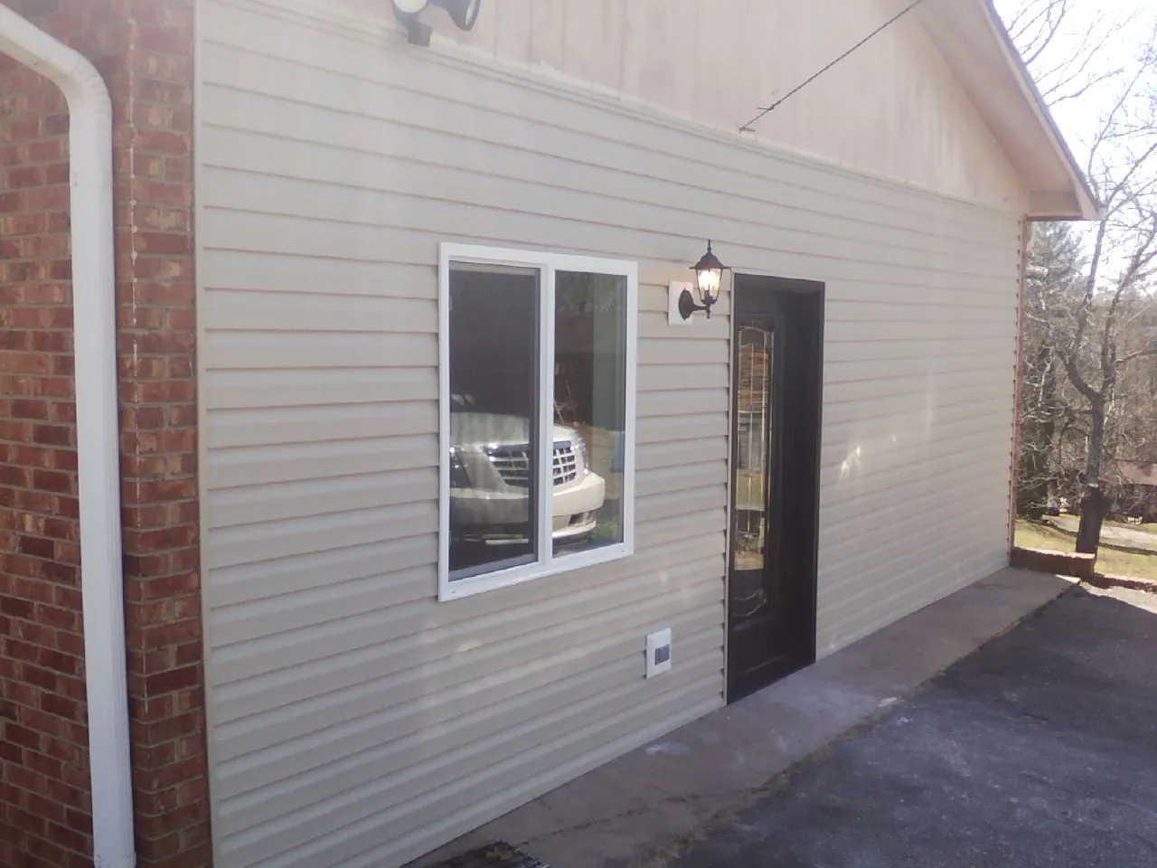 New vinyl siding and entry door on a room addition in Commerce